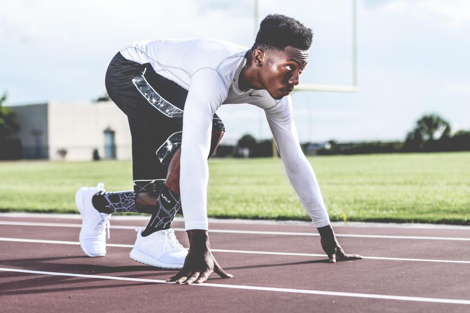 Young sprinter crouched at the start line on a school track
