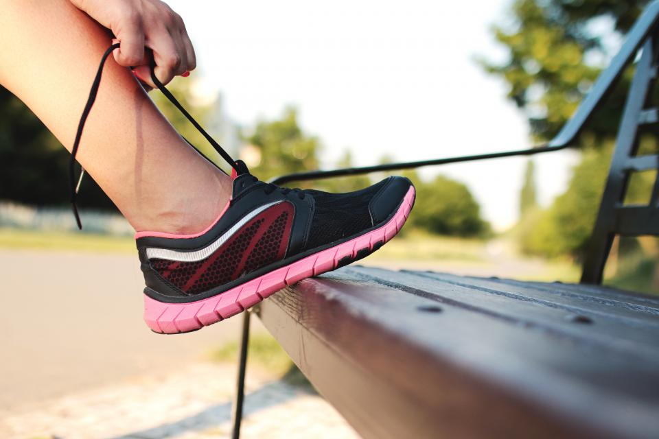 Runner tying a shoe on a park bench